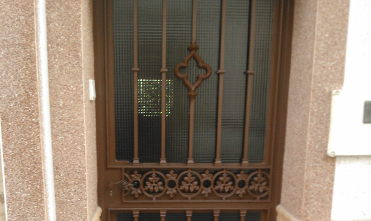 Puerta hierro con cristales y detalles de forja